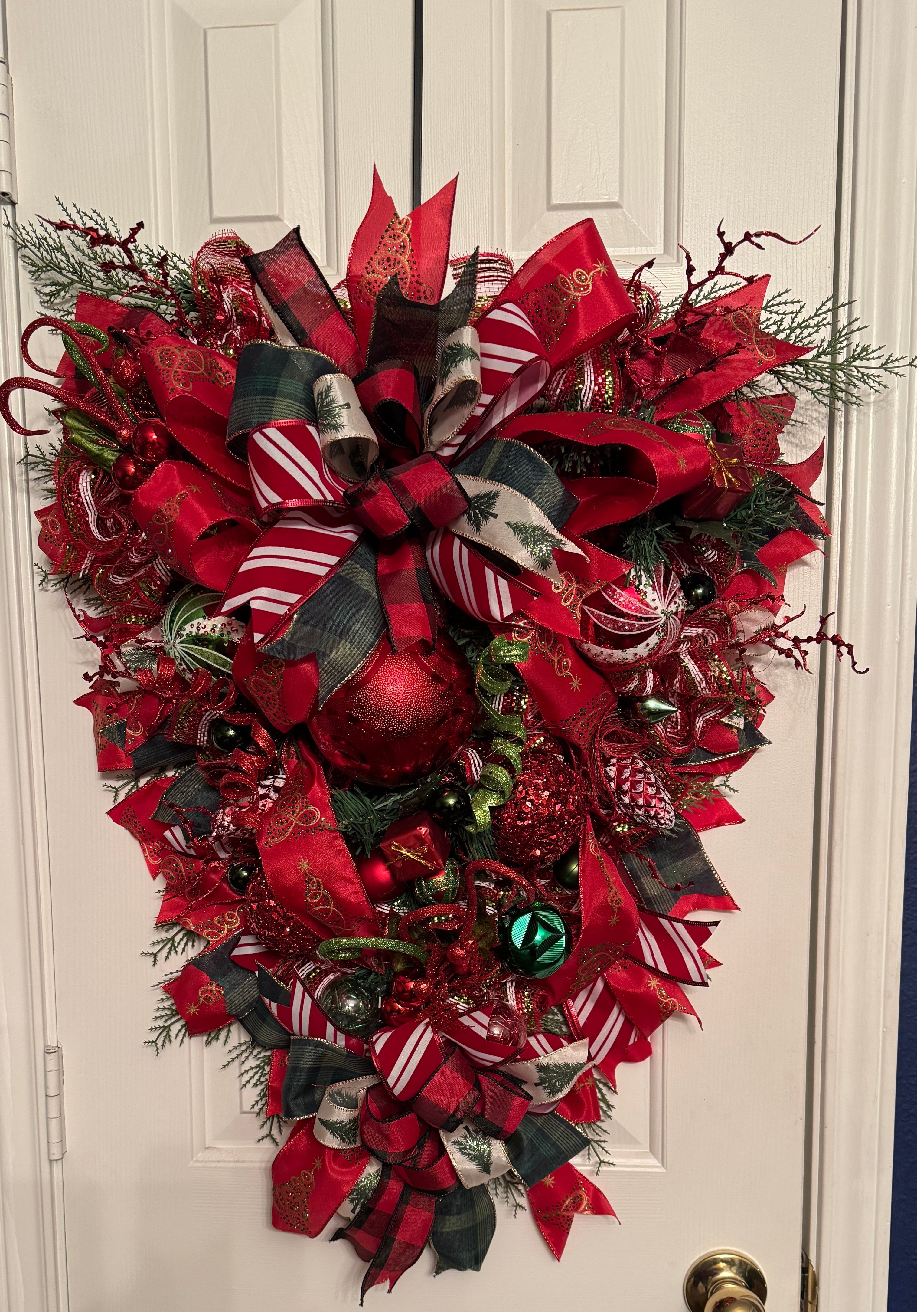 Large swag christmas Wreath in red and green with beautiful ribbons on red, green, red/white stripes and large imbedded ornaments and attachments