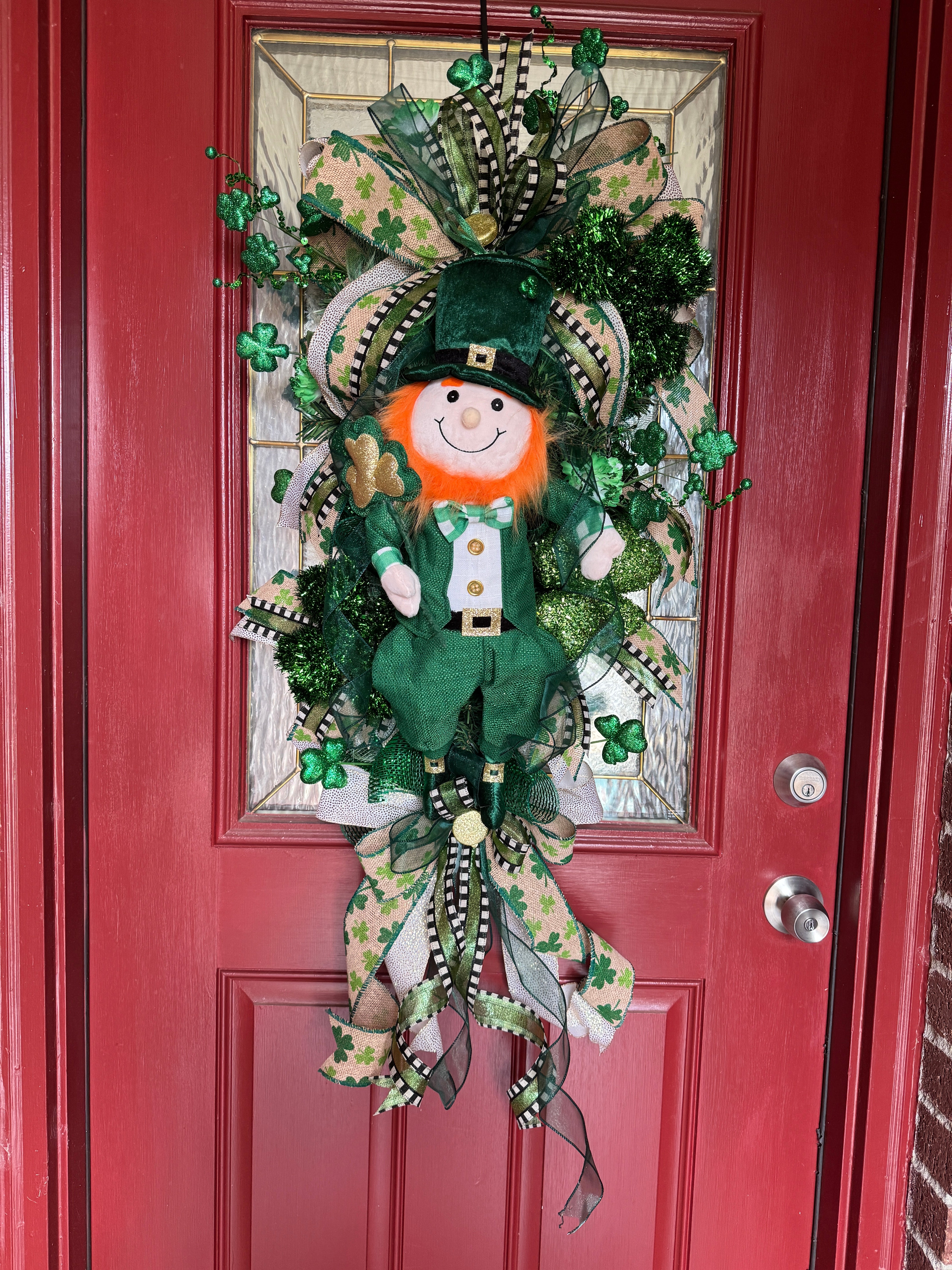 St. Patrick's Day mesh swag wreath. This is a long swag wreath in light and dark green and touches of gold-with shamrocks, coordinating ribbon bows and a large central leprechaun. 