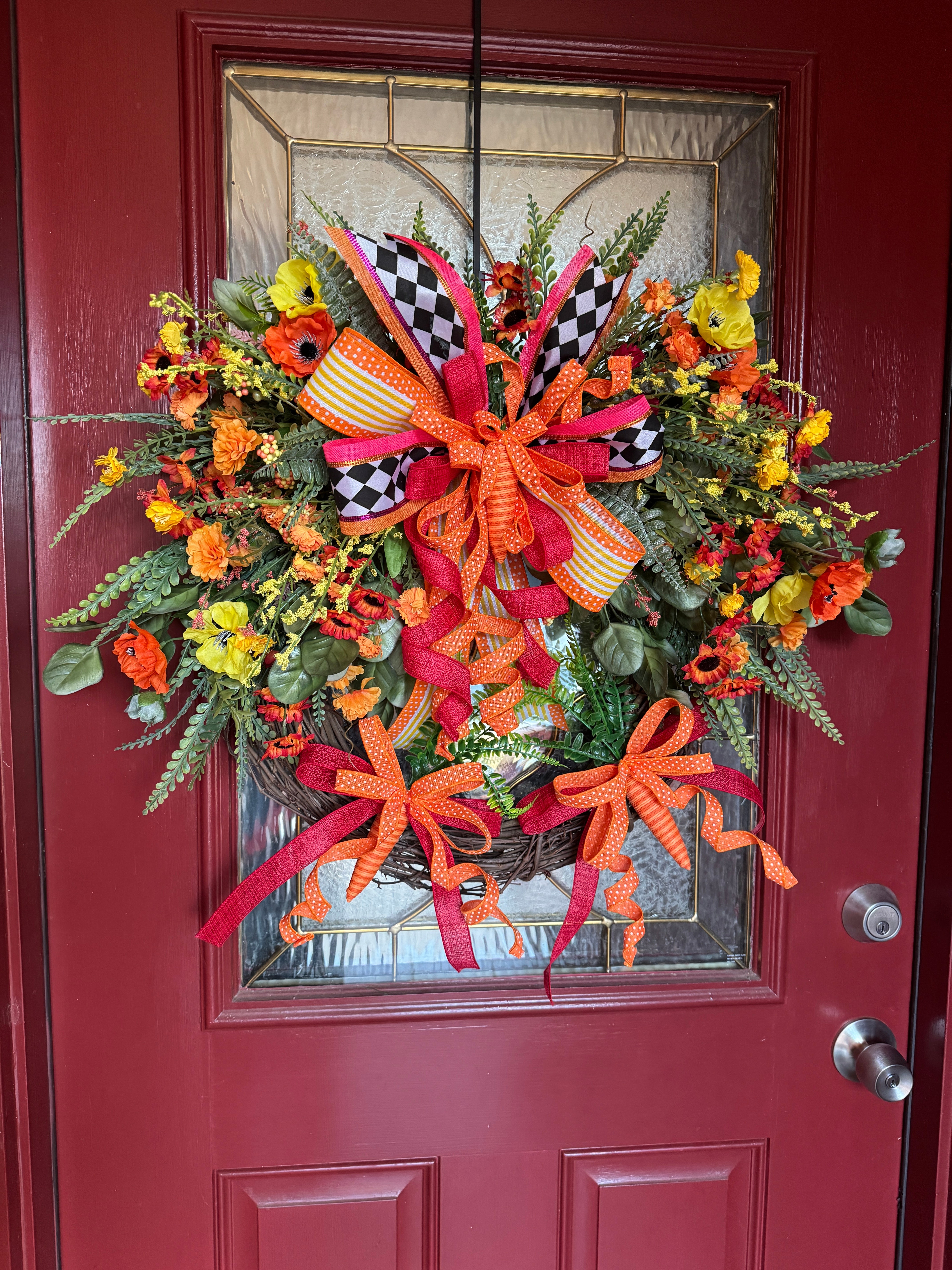 grapevine round Easter wreath with orange, and yellow flowers, matchingcoordinated ribbon, and carrot adornments